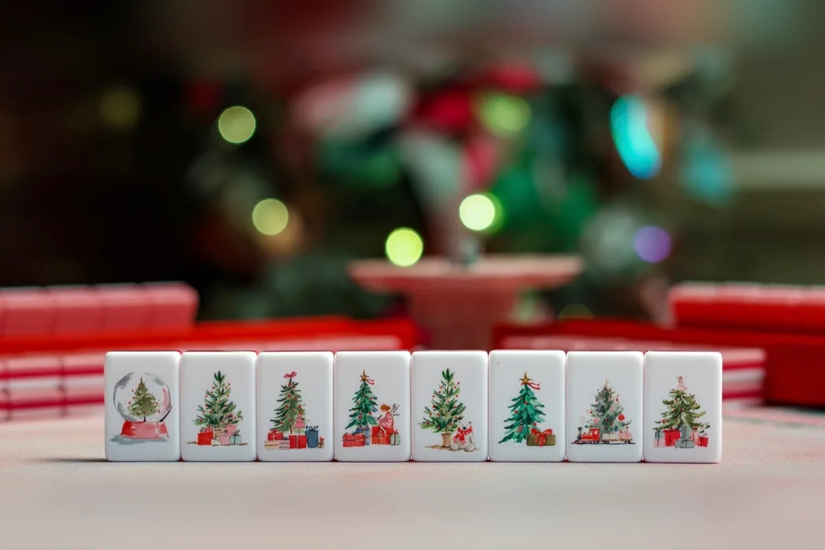 Eight Noel Collection flower tiles, each a different hand-painted Christmas tree — one in a snow globe, others with gifts, a polar bear and a toy train.
