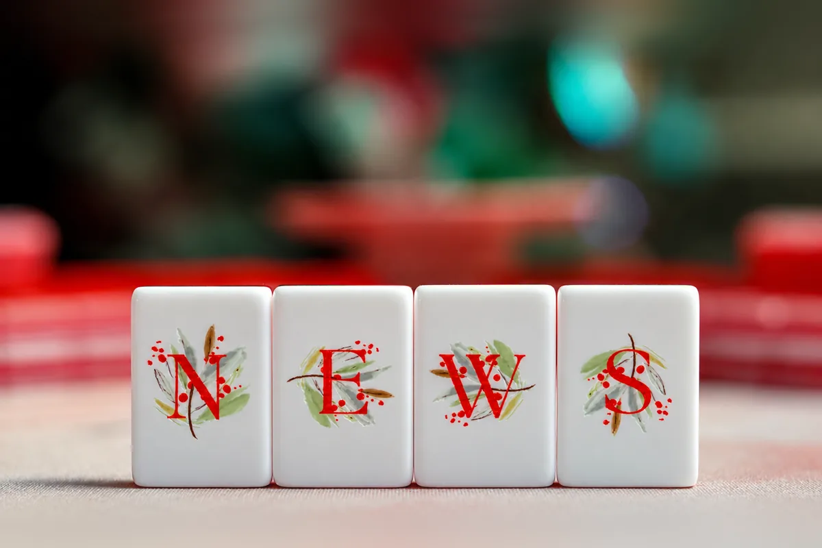 The four Noel Collection wind tiles — N, E, W and S — as red serif letters on watercolor sprigs of greenery and berries.