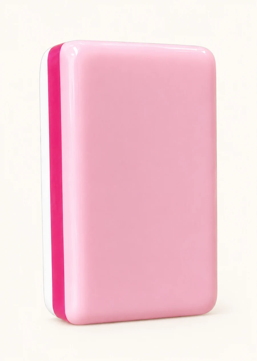 The back of a Noel Collection tile: a glossy blush-pink face with a hot-pink stripe down the edge and a white core.